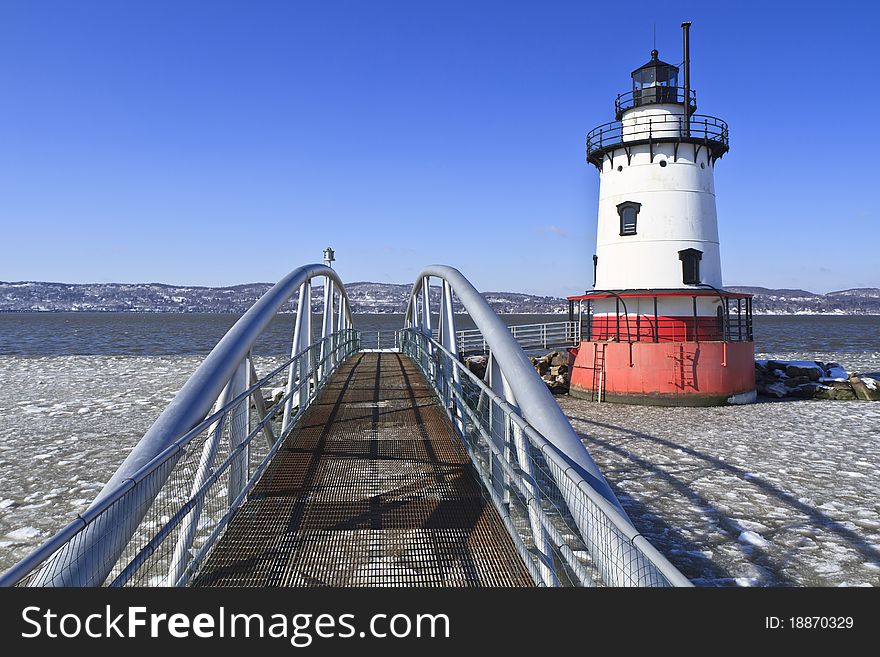 An extruded metal walkway leads to the Sleepy Hollow lighthouse on the icy Hudson River. An extruded metal walkway leads to the Sleepy Hollow lighthouse on the icy Hudson River