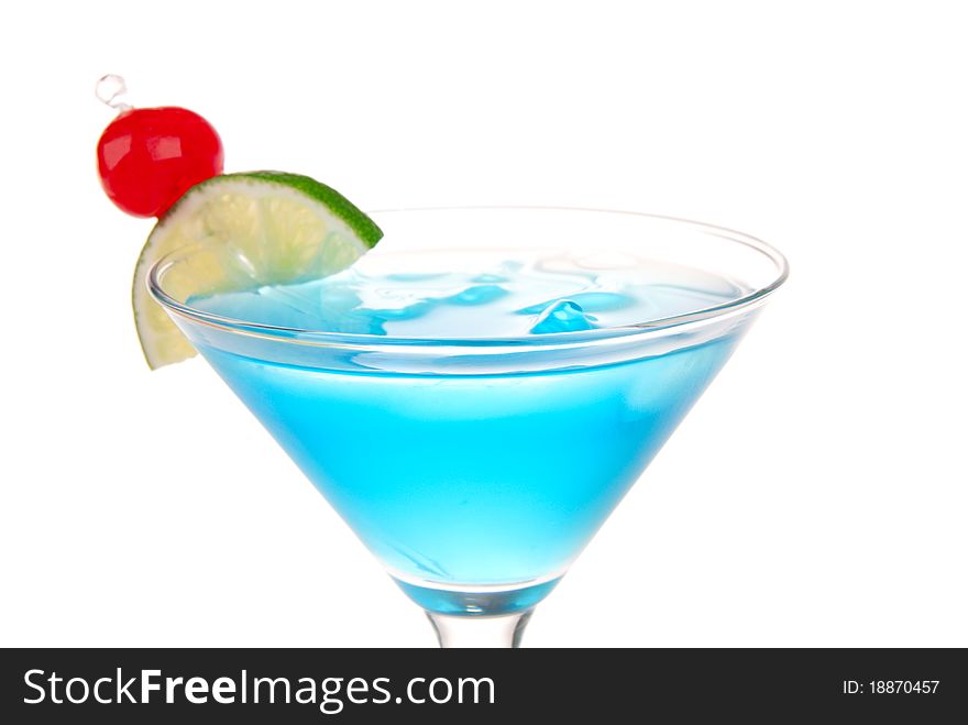 Blue Cosmopolitan cocktail with pina colada, blue curacao, white cranberry juice, lime, crushed ice and maraschino cherry in chilled martini glass isolated on a white background