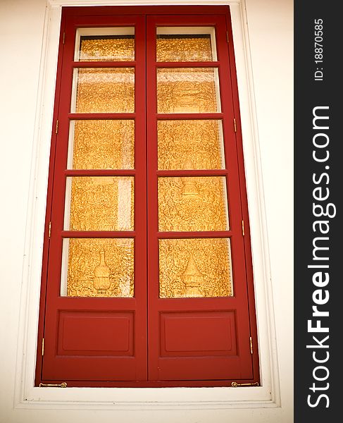 Gold and red ancient window of a temple in bangkok, thailand