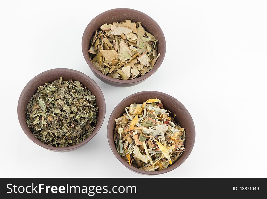 Herbal tea in small clay teacups on white background.