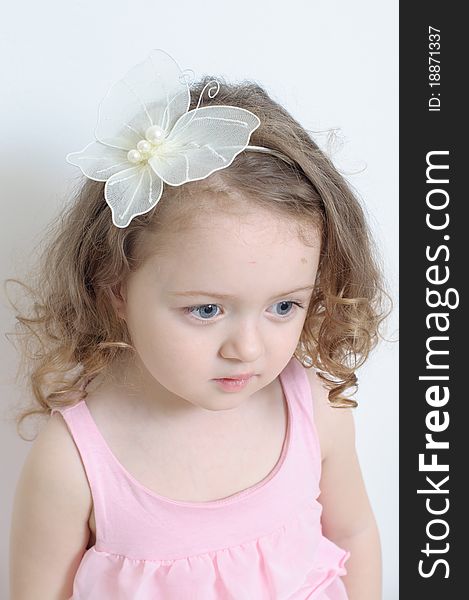 Girl in a pink dress in a white room