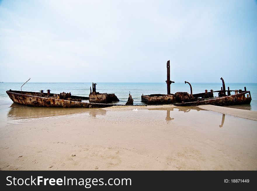 An old rusty ship thrown on a deserted beach. An old rusty ship thrown on a deserted beach