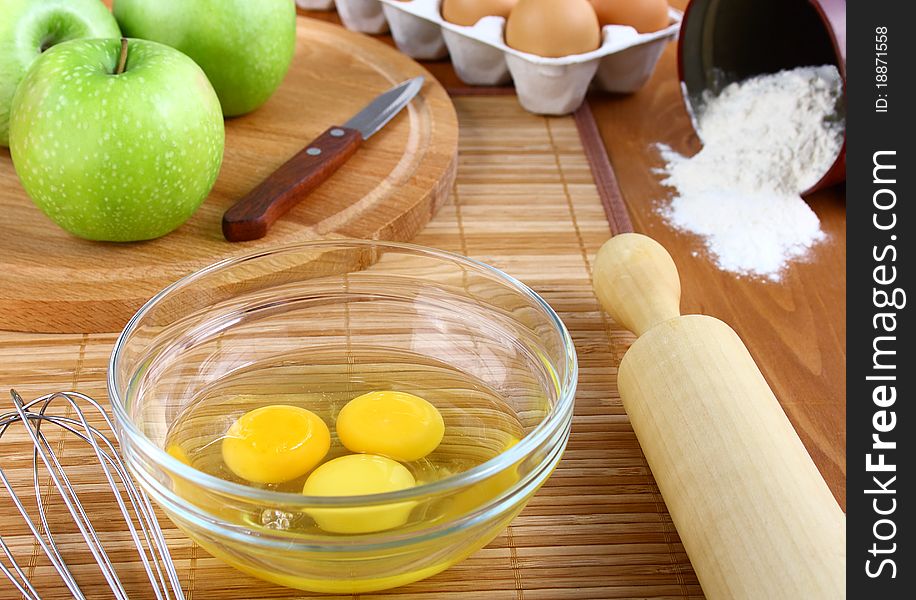 Apples, eggs and flour - components for baking apple pie.