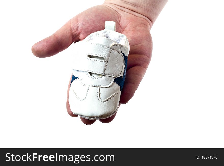 Tiny shoe in man hand on a white background. Tiny shoe in man hand on a white background