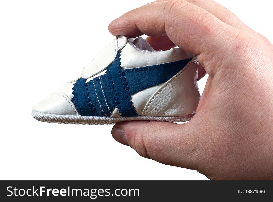 Tiny shoe in man hand on a white background. Tiny shoe in man hand on a white background