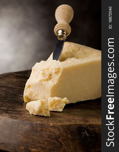 Photo of delicious italian parmesan cheese with knife on wooden table