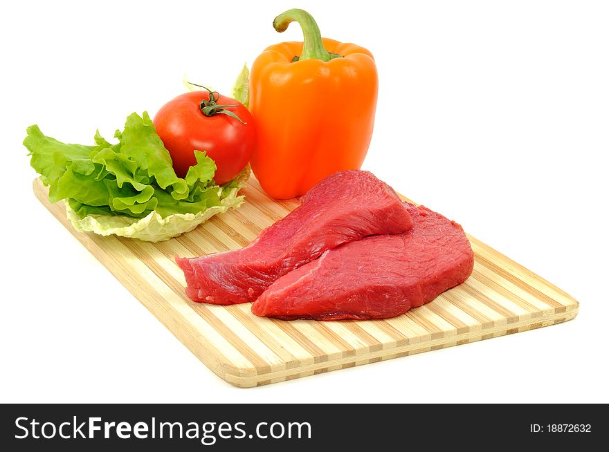 Vegetables and raw beef on wooden board, isolated on a white background. Vegetables and raw beef on wooden board, isolated on a white background