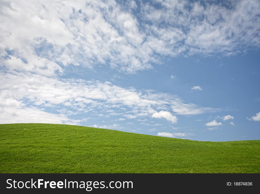 Panoramic view of nice green hill on blue sky background