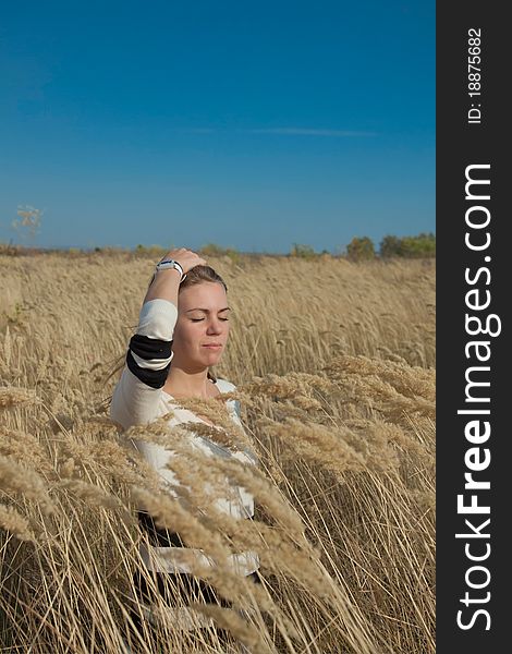 Woman standing on the field with ears of wheat. Woman standing on the field with ears of wheat.