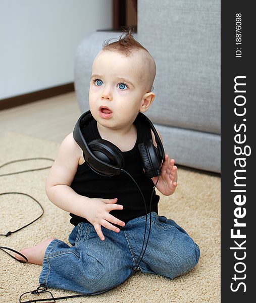 Portrait of serious baby in the earphones, background. Portrait of serious baby in the earphones, background