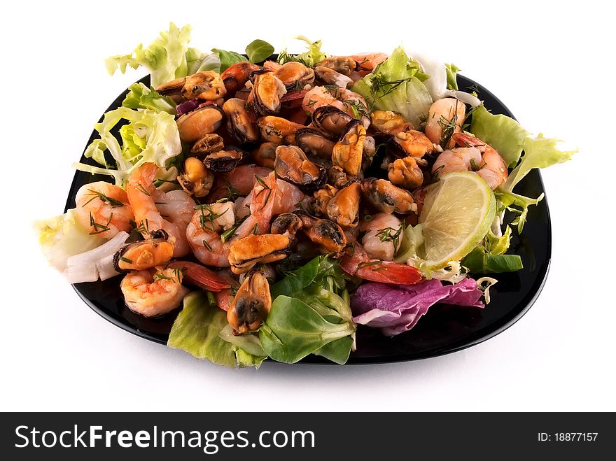 A photo of salad with seafood and lettuce on a black square plate. Another angle. A photo of salad with seafood and lettuce on a black square plate. Another angle.