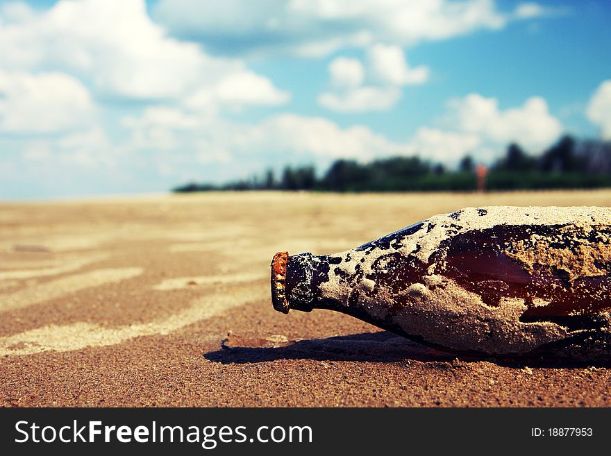 Bottle lying in the sand by the river. Bottle lying in the sand by the river