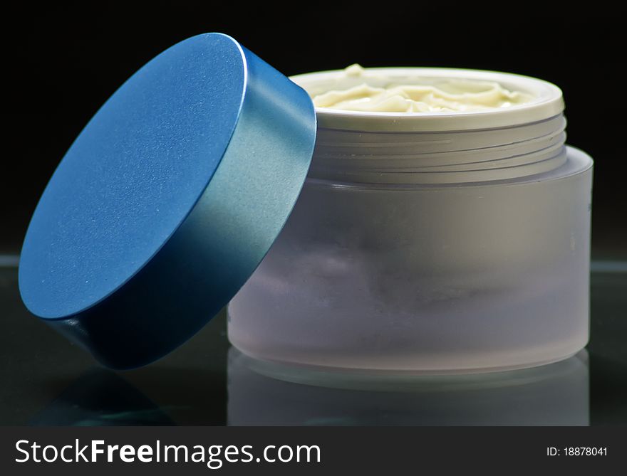 Cream container with amazing colors in dark background