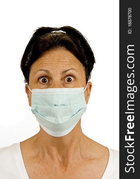 A surgical mask is used to protect from germs. This woman is fearful of catching something like the flu, etc. Isolated on white. Studio shot. A surgical mask is used to protect from germs. This woman is fearful of catching something like the flu, etc. Isolated on white. Studio shot.