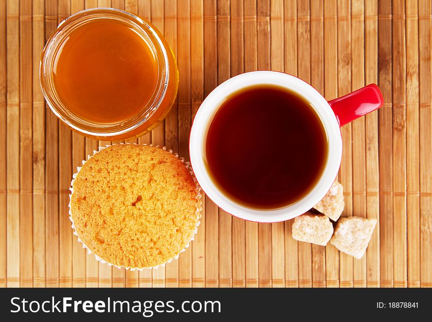 Cup of sweet tea with cake and honey. Cup of sweet tea with cake and honey