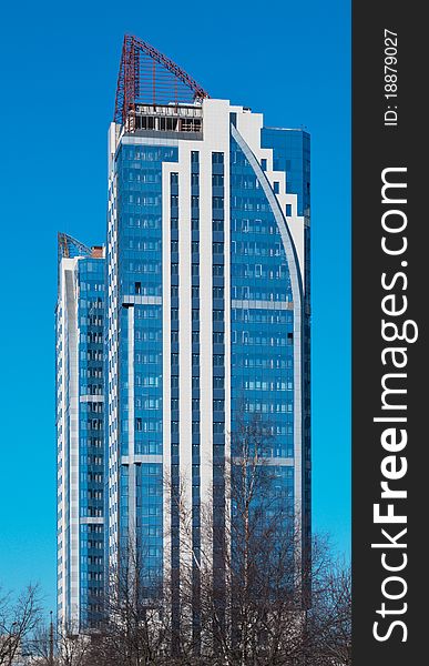 Modern high-rise apartment building against the blue cloudless sky.