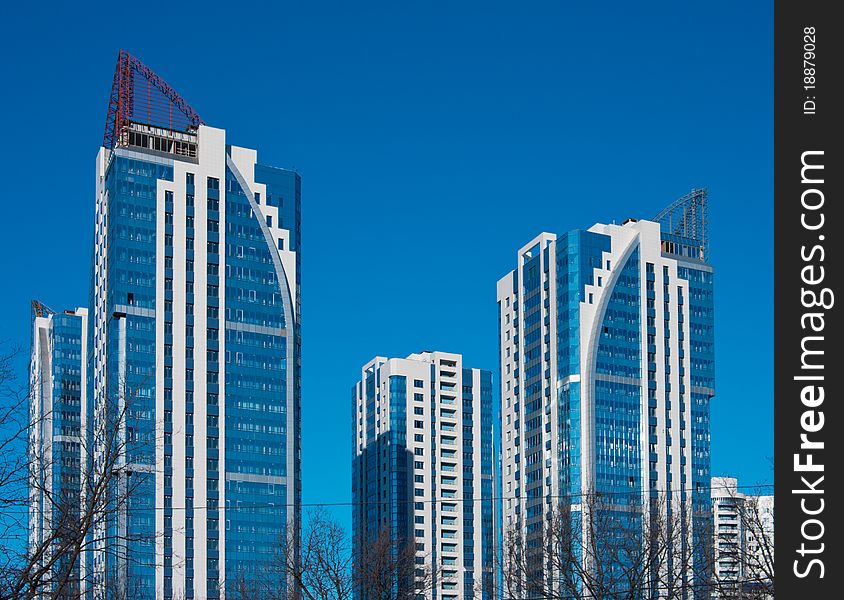 High-rise modern residential complex of four buildings on a background of blue sky. High-rise modern residential complex of four buildings on a background of blue sky.