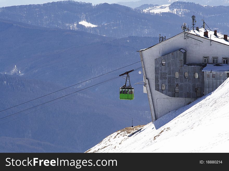 Green cable car departure in Carpathians Mountains