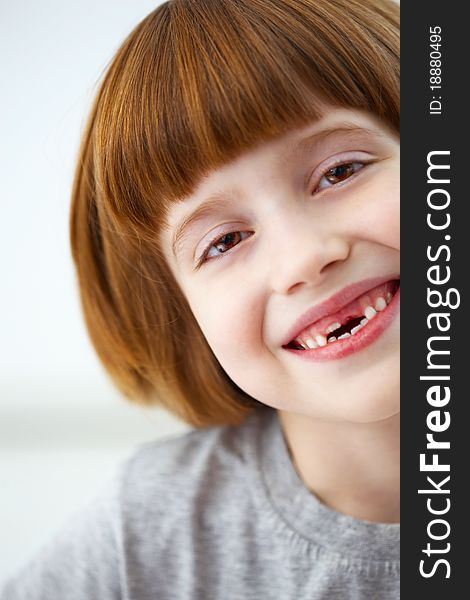 Closeup portrait of a cute smiling girl missing front teeth