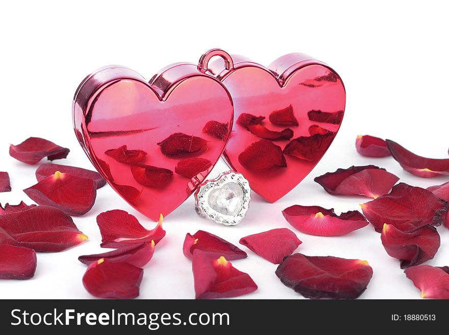 Red heart in box and petals on white background