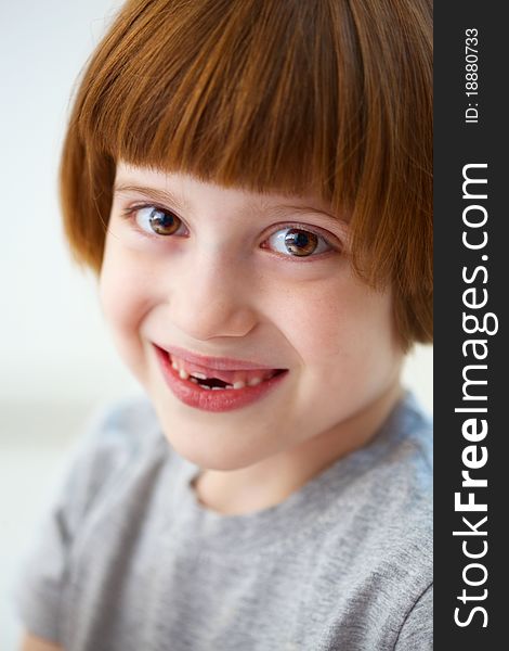 Closeup portrait of a cute smiling girl missing front teeth