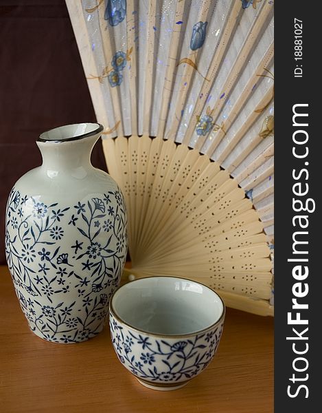 Japanese Sake set with wooden fan background.