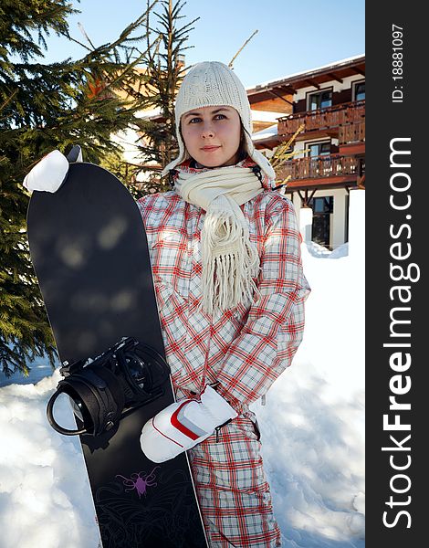 Young boarder girl with a snowboard in a ski resort. Young boarder girl with a snowboard in a ski resort