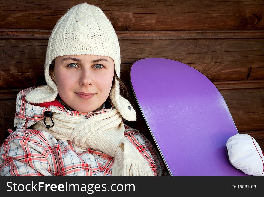 Closeup portrait of young boarder girl with a snowboard in a ski resort. Closeup portrait of young boarder girl with a snowboard in a ski resort
