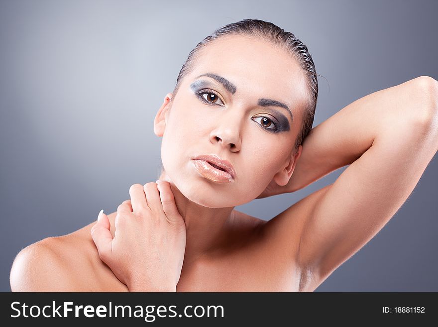 Closeup portrait of brunette woman looking at camera touching neck. Closeup portrait of brunette woman looking at camera touching neck