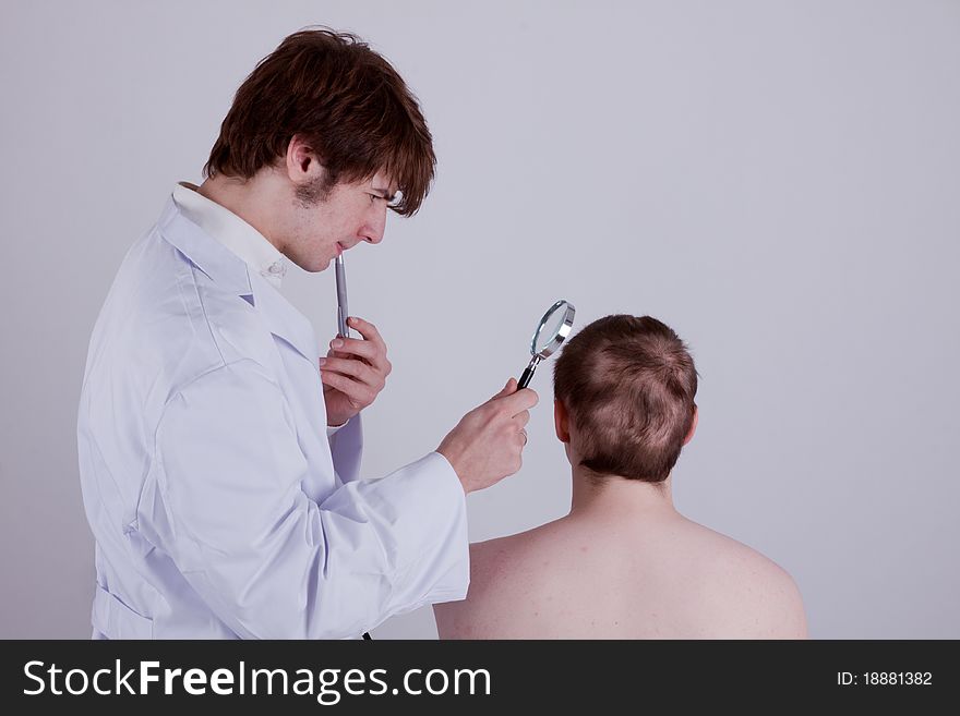 A doctor examines the skin of a patient with a magnifier. A doctor examines the skin of a patient with a magnifier