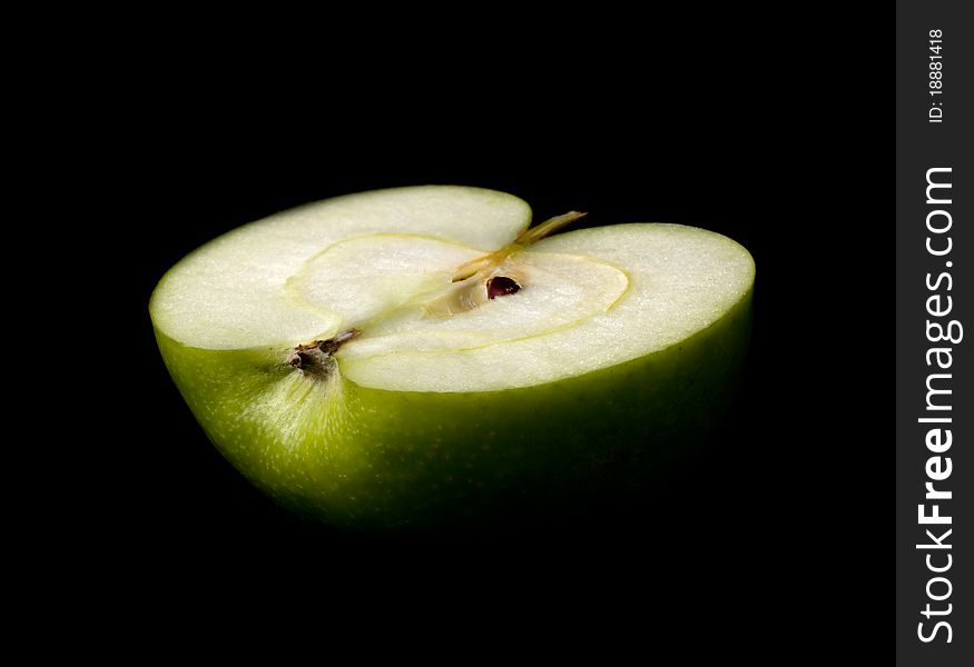 Green apple half slice on black background