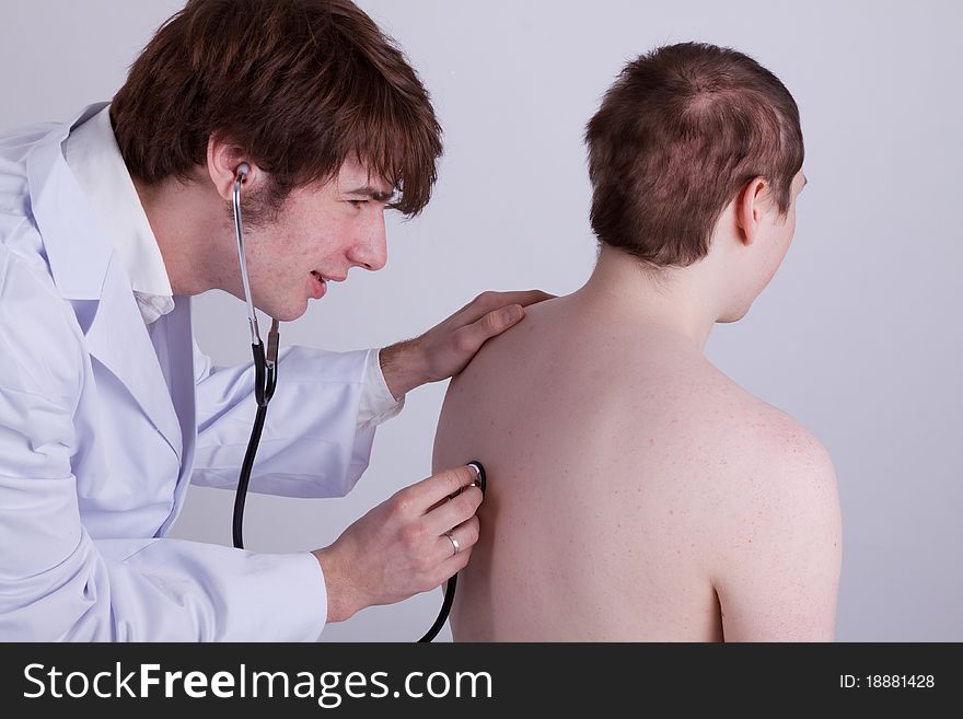 A doctor examines a patient with a stethoscope. A doctor examines a patient with a stethoscope