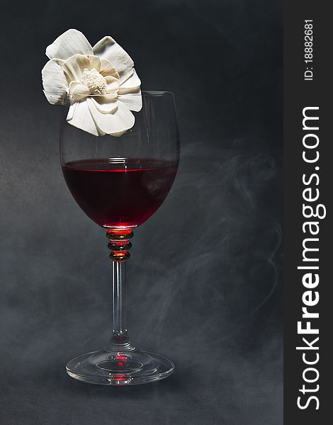 Glass of red wine and a flower isolated on black background. Glass of red wine and a flower isolated on black background