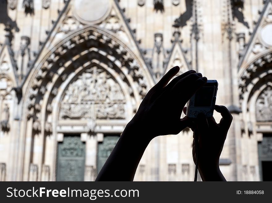 Hands with a camera in front of cathedral St. Vitius in Prague