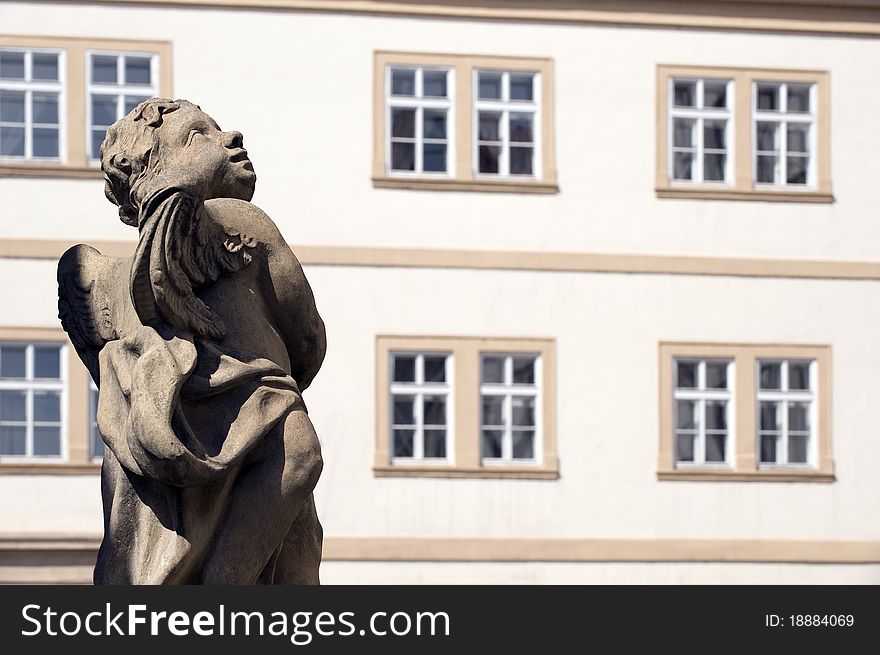 Windows and statue, old apartment building in Prague