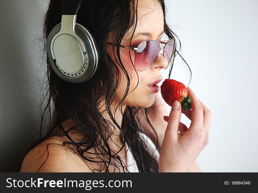 Happy woman dance in phones and eat strawberry. Happy woman dance in phones and eat strawberry