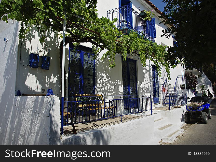 Traditional greek house painted in white with blue details at sunny summer day. Traditional greek house painted in white with blue details at sunny summer day.