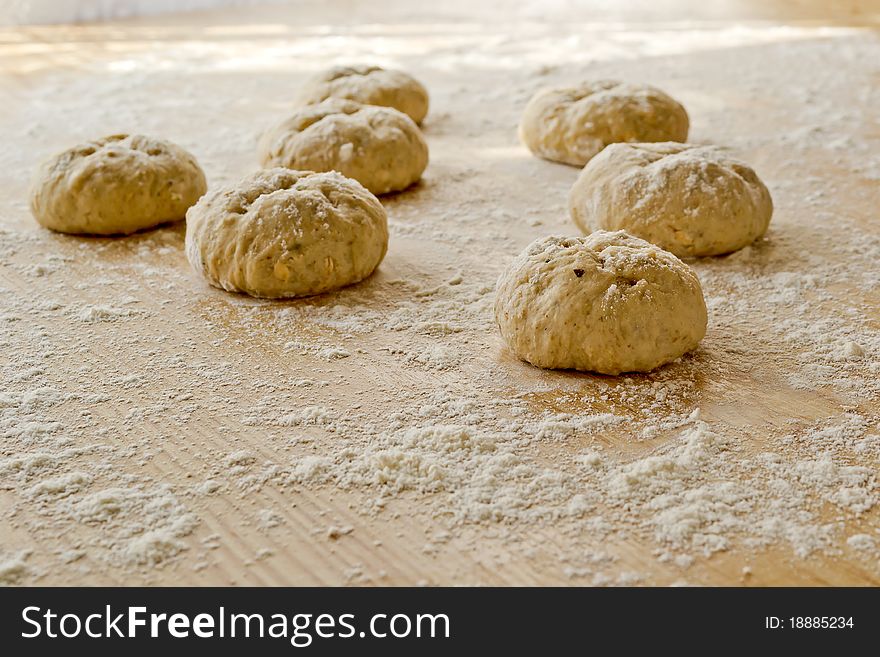 Bread dough balls on a table sprinkled with flour