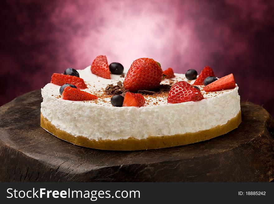 Photo of delicious cake with strawberries on wooden table