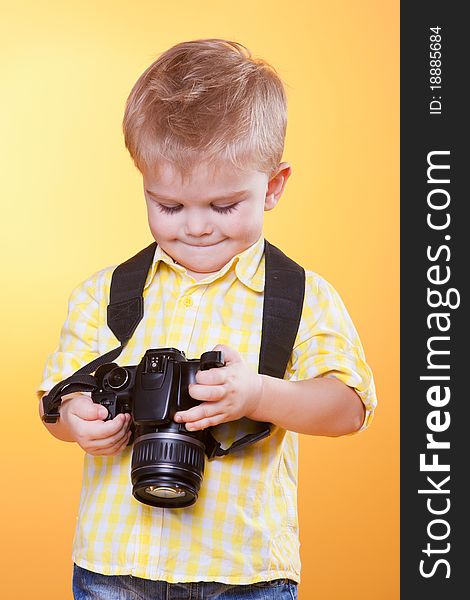 Little smiling photographer watching photo on professional camera. Little smiling photographer watching photo on professional camera