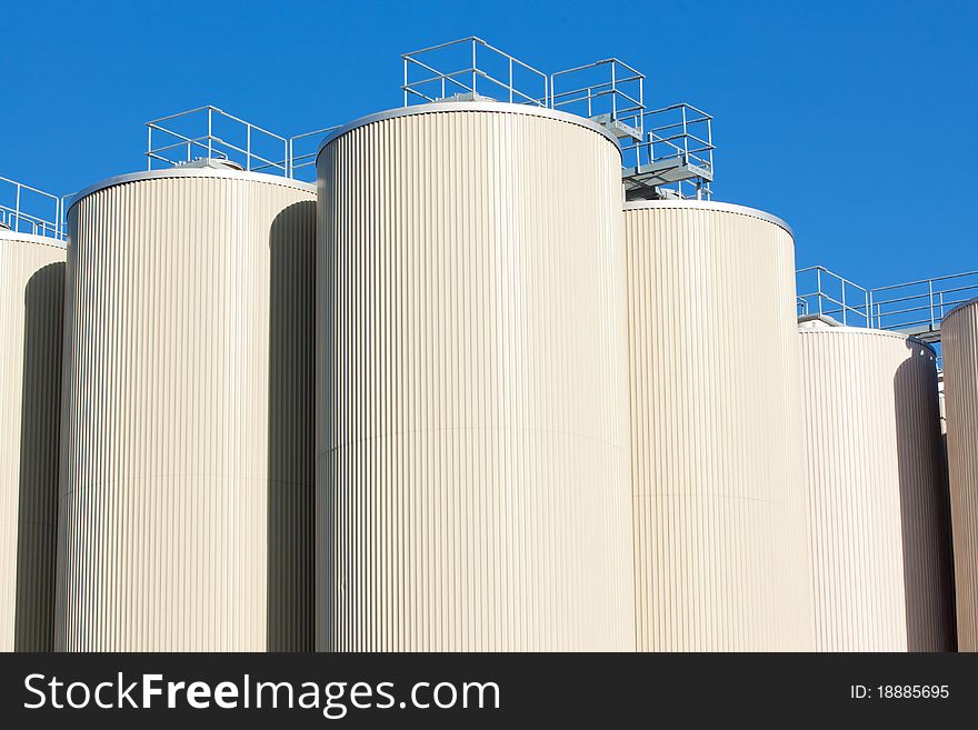 Refinery oil storage tanks and blue clear sky in background. Refinery oil storage tanks and blue clear sky in background