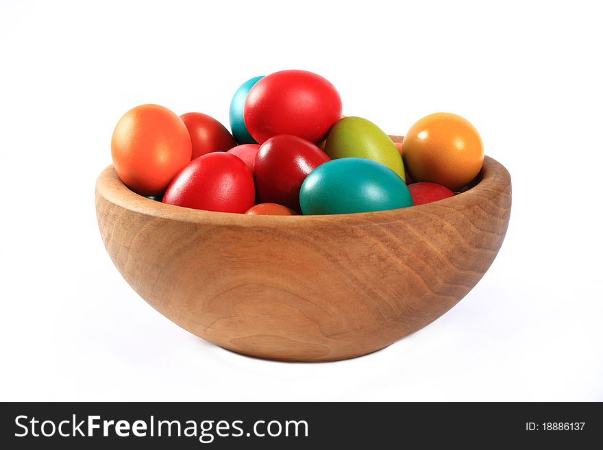 Easter eggs in a wooden bowl on a white background