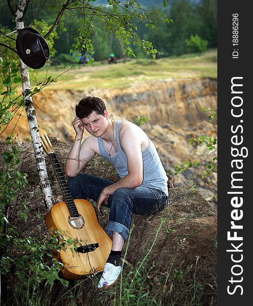 A lone young man with a guitar against breakage. A lone young man with a guitar against breakage