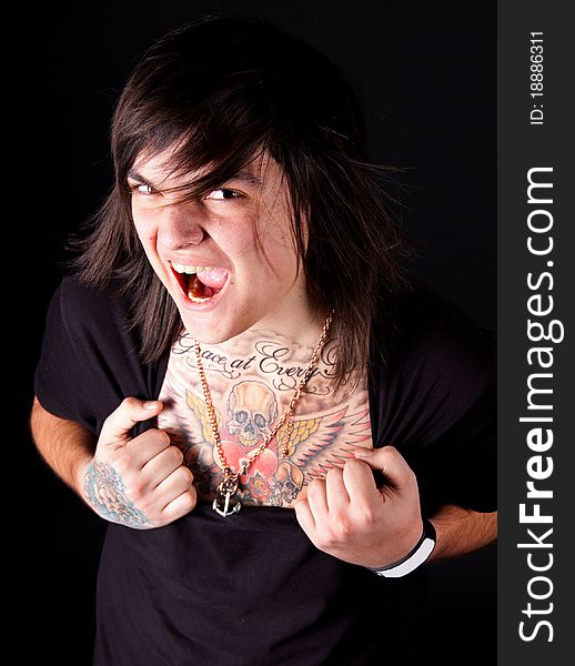 Young handsome man with tattoos posing over black. Young handsome man with tattoos posing over black