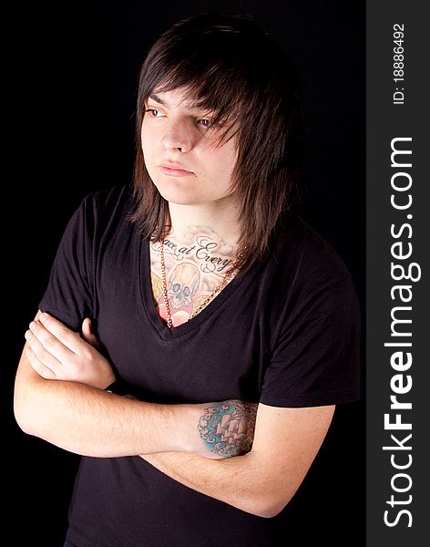 Young handsome man with tattoos posing over black. Young handsome man with tattoos posing over black