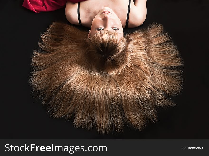 Pretty young woman lying on the black