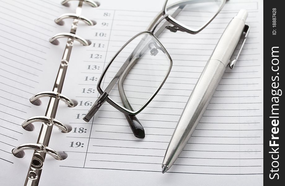 Close-up notebook, pen and glasses