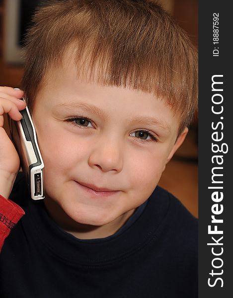 Young child holding a mobile phone and making a call. Young child holding a mobile phone and making a call