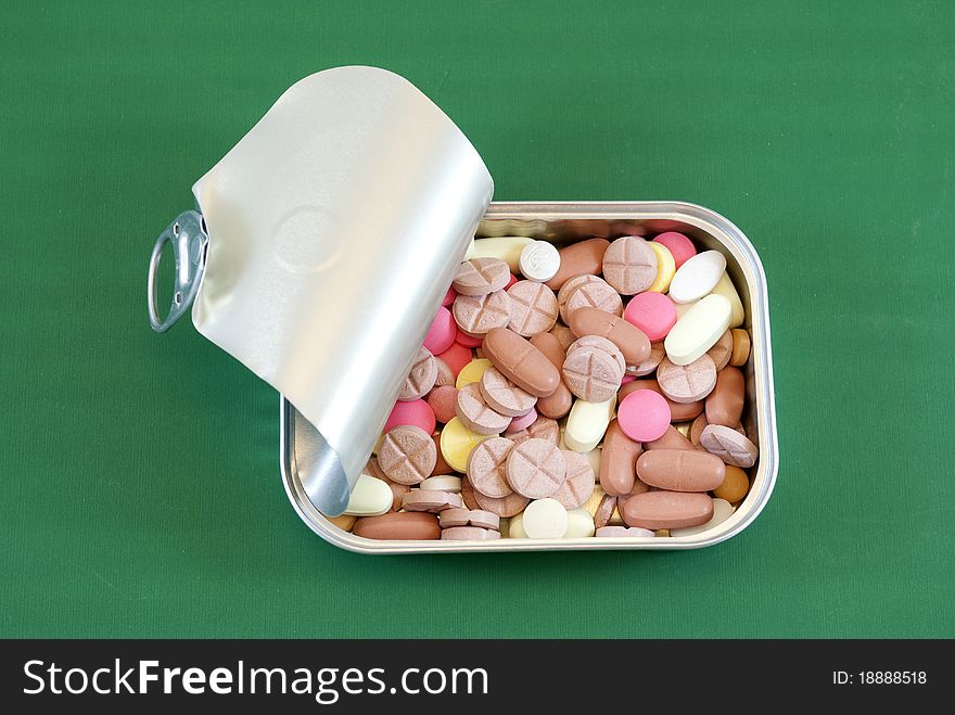 Tin of sardines with pills of different colors. Tin of sardines with pills of different colors