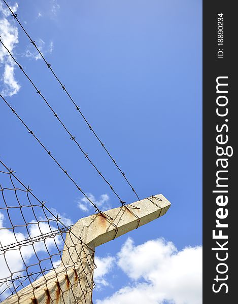 Fence With Barbed Wire Under Blue Sky